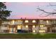 Charming condo building with a well-maintained lawn and private balconies at sunset at 10211 Ura Ln # 1-202, Thornton, CO 80260