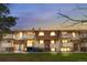 Charming condo building with a well-maintained lawn and private balconies at dusk at 10211 Ura Ln # 1-202, Thornton, CO 80260
