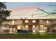 Inviting townhouse exterior with balconies, dormer windows and mature trees at sunset at 10211 Ura Ln # 1-202, Thornton, CO 80260