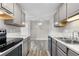 Updated kitchen features modern appliances, gray cabinets, sleek countertops, and wood-look flooring at 10211 Ura Ln # 1-202, Thornton, CO 80260