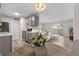 Stylish kitchen with gray cabinets, stainless steel appliances, open to a staged living and dining area at 10211 Ura Ln # 1-202, Thornton, CO 80260