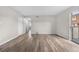 Open-concept living room with a sliding glass door and light wood flooring at 10211 Ura Ln # 1-202, Thornton, CO 80260