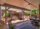 Outdoor covered back deck featuring ample seating, a dining area, and a view of the brick-wall backyard at 5231 S Cody St, Littleton, CO 80123