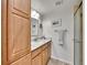 Clean bathroom features a granite countertop, light wood cabinets, a framed mirror, and a glass enclosed shower at 5231 S Cody St, Littleton, CO 80123