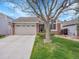 Charming home features a two-car garage and a well-maintained front lawn and landscape, complete with a tree at 5231 S Cody St, Littleton, CO 80123