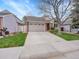 Charming home features a two-car garage and a well-maintained front lawn and landscape, complete with a tree at 5231 S Cody St, Littleton, CO 80123