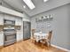 Eat-in kitchen featuring stainless steel appliances, granite countertops, and a vaulted ceiling with a skylight at 5231 S Cody St, Littleton, CO 80123