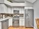Bright eat-in kitchen with stainless steel appliances, granite countertops, and white cabinets, a chef's dream at 5231 S Cody St, Littleton, CO 80123