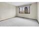 Empty bedroom with a window overlooking greenery, and neutral-colored walls and carpet at 2615 Oak Dr # 5, Lakewood, CO 80215