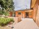 Brick patio features sliding glass door, entry door with security door, and brick privacy wall at 2615 Oak Dr # 5, Lakewood, CO 80215