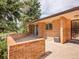 Brick patio features sliding glass door, entry door with security door, and brick privacy wall at 2615 Oak Dr # 5, Lakewood, CO 80215