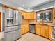 Modern kitchen with stainless steel refrigerator, light wood cabinets, and a window over the sink at 2615 Oak Dr # 5, Lakewood, CO 80215