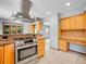 Well-equipped kitchen showcasing stainless steel appliances, tile flooring, and wooden cabinets at 2615 Oak Dr # 5, Lakewood, CO 80215
