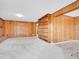 An open living room featuring wood paneling, built-in shelves and leads to an adjacent tiled area at 2615 Oak Dr # 5, Lakewood, CO 80215