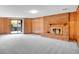 Spacious living room featuring a brick fireplace, wood paneled walls, and sliding glass door to the outside at 2615 Oak Dr # 5, Lakewood, CO 80215