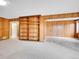 Living room showcasing built-in shelving, wood paneled walls, and carpet and tiled flooring at 2615 Oak Dr # 5, Lakewood, CO 80215
