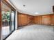 Expansive living room with wood paneled walls, carpet floors, and a brick fireplace, flooded with natural light at 2615 Oak Dr # 5, Lakewood, CO 80215