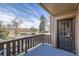 Private balcony with street views, featuring wood railings and access to the unit at 6504 Ralston Rd # A, Arvada, CO 80002