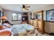 Well-lit bedroom with carpet and a window featuring a wooden ceiling fan and dresser with a mirror at 6504 Ralston Rd # A, Arvada, CO 80002