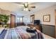 Bedroom features a colorful quilt, a ceiling fan, and a large dresser with a television at 6504 Ralston Rd # A, Arvada, CO 80002