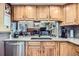 Traditional kitchen with wood cabinets, stainless steel appliances and view of the living room at 6504 Ralston Rd # A, Arvada, CO 80002