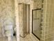 Bathroom featuring toilet, glass block wall and shower at 5521 Colorow Dr, Morrison, CO 80465