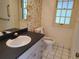 Cozy bathroom featuring a pedestal sink, tiled floors, and a bright window for natural light at 5521 Colorow Dr, Morrison, CO 80465