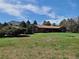 Expansive front yard with lush lawn, mature trees, and charming single-story home at 5521 Colorow Dr, Morrison, CO 80465