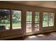 Bright living room with large windows and french doors, offering beautiful views of the outdoor space at 5521 Colorow Dr, Morrison, CO 80465