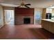 Spacious living area with a brick fireplace, adjacent kitchen and views to another living area at 5521 Colorow Dr, Morrison, CO 80465