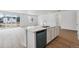 Bright kitchen featuring a kitchen island with sink and stainless steel dishwasher at 9072 Telluride Ct, Commerce City, CO 80022