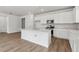 Bright kitchen featuring white cabinets, stainless steel appliances, and an island with a sink at 9072 Telluride Ct, Commerce City, CO 80022