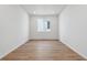 Bright living room with hardwood floors, white walls, and a large window at 9072 Telluride Ct, Commerce City, CO 80022