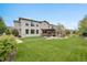 An expansive backyard features a manicured lawn, putting green, outdoor kitchen, and pergola covered patio at 10738 Braesheather Ct, Highlands Ranch, CO 80126