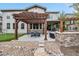 Backyard with a pergola over an outdoor dining area, fire pit, and a putting green at 10738 Braesheather Ct, Highlands Ranch, CO 80126