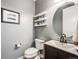 Modern half bathroom with stylish fixtures, floating shelves, and a round mirror above the vanity at 10738 Braesheather Ct, Highlands Ranch, CO 80126