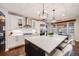 Spacious kitchen with white cabinets, stainless steel appliances, and a large center island with pendant lights at 10738 Braesheather Ct, Highlands Ranch, CO 80126