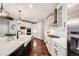 Stylish kitchen with white cabinetry, stainless steel appliances, farmhouse sink, and a spacious center island at 10738 Braesheather Ct, Highlands Ranch, CO 80126