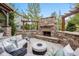 Outdoor stone fireplace with cushioned seating, perfect for entertaining guests at 10738 Braesheather Ct, Highlands Ranch, CO 80126