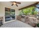 A built-in stone-clad outdoor grill features stainless steel appliances, and a view of the wooded back yard at 10738 Braesheather Ct, Highlands Ranch, CO 80126
