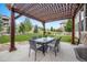 A covered outdoor patio includes a table and seating for six, set on a concrete slab adjacent to a putting green at 10738 Braesheather Ct, Highlands Ranch, CO 80126