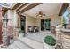 Covered patio with brick pillars, ceiling fan, rocking chairs, and outdoor planters at 10738 Braesheather Ct, Highlands Ranch, CO 80126