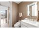 Bathroom with a modern vanity, lighted mirror, and textured wallpaper, offering a glimpse into the adjacent bedroom at 2400 E Cherry Creek South Dr # 209, Denver, CO 80209