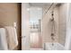 Bright bathroom featuring a modern shower, neutral tile, and a view into the bedroom through an open door at 2400 E Cherry Creek South Dr # 209, Denver, CO 80209