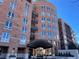 Elegant building entrance featuring a covered entryway, glass doors, and manicured landscaping at 2400 E Cherry Creek South Dr # 209, Denver, CO 80209