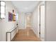 Bright hallway with hardwood floors, decorative lighting, colorful artwork, and doors leading to other rooms at 2400 E Cherry Creek South Dr # 209, Denver, CO 80209