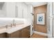 Modern laundry room includes white cabinets, a utility sink, and a stacked washer and dryer at 2400 E Cherry Creek South Dr # 209, Denver, CO 80209