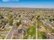 An aerial view shows the property located near open green spaces, recreational facilities, and a pond at 13020 Julian Ct, Broomfield, CO 80020