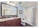 Well-lit bathroom with a granite vanity, dark wood cabinets, and shower-tub combo at 16459 W 86Th Pl # B, Arvada, CO 80007