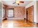 Bright bedroom featuring hardwood floors, exposed brick, and classic doors at 1451 Madison St # 3, Denver, CO 80206